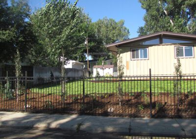 Alternate angle of landscaped home with new fence